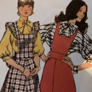 Può includere: Due donne indossano due diversi stili di salopette a quadri. La donna a sinistra indossa una blusa gialla con un fiocco e una salopette a quadri con un colletto a volant. La donna a destra indossa una blusa a righe bianche e nere con un fiocco e una salopette rossa.