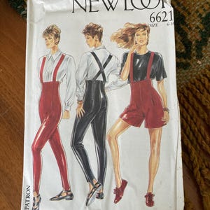 May include: A vintage sewing pattern labelled "NEWLOOK 6621" showing illustrations of three models in outfits with suspenders. The outfits include red leggings, black trousers, and red shorts. The pattern size is 6-16.