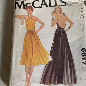 Puede incluir: Patrón de costura vintage de McCall's con ilustraciones de dos vestidos con cuello halter. Un vestido es amarillo, el otro es marrón oscuro. El patrón incluye el texto "McCall's", "BASLE" y el número "6617". El precio es de $2.00.