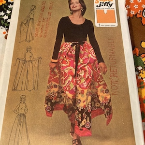 May include: A vintage sewing pattern featuring a woman wearing a long-sleeved black top and a colorful skirt with a floral pattern. The pattern includes illustrations and text, with the words "Super Jiffy" and "NOT RETURNABLE" visible.