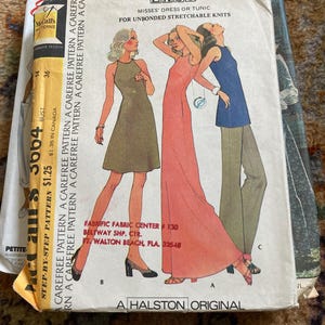 May include: A McCall's sewing pattern envelope for a dress or tunic, numbered 3664. The cover displays illustrations of three figures wearing a short olive dress, a long coral dress, and a blue sleeveless top with tan trousers. Text includes "EASY", "A HALSTON ORIGINAL", and store details.