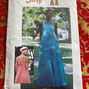 May include: Simplicity pattern number 7454, Jiffy, for a maxi dress. The pattern shows two models wearing the dress, one in a blue tie-dye print and the other in a pink floral print. The pattern is for sizes 12-14.