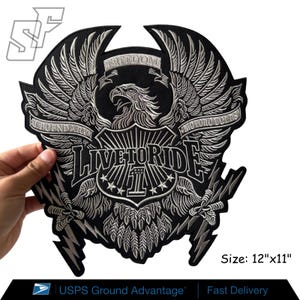 May include: A large black and silver embroidered patch featuring a central eagle with spread wings, a shield with the number 1, and the text "LIVE TO RIDE", "LEGENDARY", "MOTORCYCLES", and "FREEDOM". The patch measures 12 inches by 11 inches.