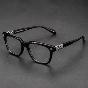 Puede incluir: Gafas de acetato negro con montura de forma rectangular. Las patillas están adornadas con intrincados emblemas de cruz de metal plateado en las bisagras. La patilla interior muestra el texto Chrome Hearts en una fuente blanca sin remates.