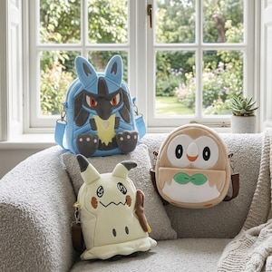 May include: Three plush character bags featuring a blue and black Lucario design with a light blue strap, a cream-colored Mimikyu design with brown accents, and a round tan and white Rowlet design with a green bowtie and brown shoulder straps.