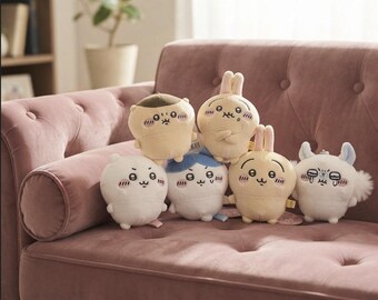 May include: A collection of six small, round plush toys featuring various cartoon characters with expressive faces, including white, cream, and light blue colors, arranged together in a group with some figures having small ears or tufts of hair.