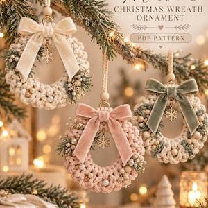May include: Three macrame Christmas wreath ornaments with velvet bows, pearl beads, and snowflake charms. The text reads Macrame CHRISTMAS WREATH ORNAMENT PDF PATTERN. The wreaths are cream, dusty pink, and sage green with cream cord.