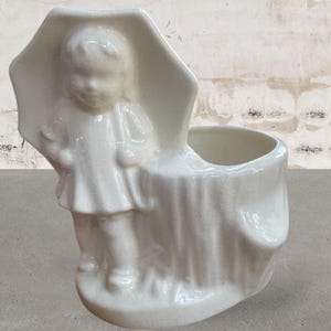 May include: A set of three ceramic mugs with a speckled, matte finish. The mugs are in shades of cream, light gray, and dark gray. Each mug has a simple, minimalist design, perfect for coffee or tea.