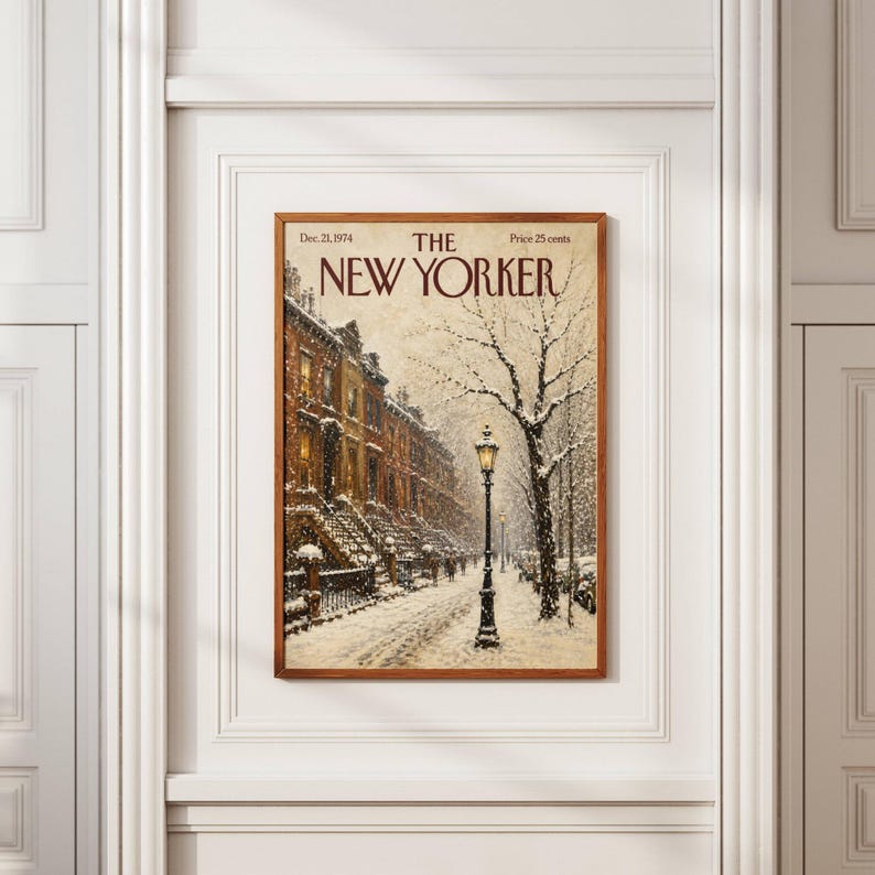 May include: A framed print of The New Yorker magazine cover dated Dec. 21, 1974, featuring a snowy city street scene with brownstone buildings, a lit street lamp, and bare trees under a winter sky, all enclosed in a simple wooden frame.
