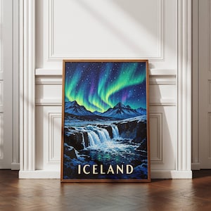 May include: A rectangular wall art print in a wooden frame featuring a landscape of snow-capped mountains and a cascading waterfall under a vibrant green and purple aurora borealis night sky, with the word ICELAND printed at the bottom.