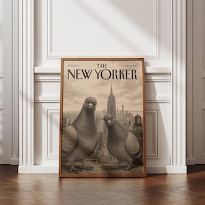 May include: A framed print of a vintage The New Yorker magazine cover dated May 13, 2006. The illustration features two pigeons in the foreground with a detailed black and white cityscape of New York City, including the Empire State Building, behind them.