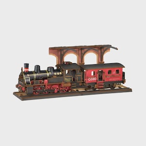 May include: A wooden model steam locomotive and passenger car set on a track with a station platform canopy. The engine is black with red wheels and gold accents, while the passenger car is red with the text Q350 and Rolife branding.