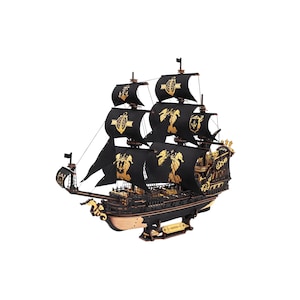 May include: A model ship featuring black sails adorned with gold seahorse and anchor emblems. The vessel has a dark hull with gold decorative accents, multiple masts with rigging, and a seahorse figurehead at the bow, all mounted on a stand.