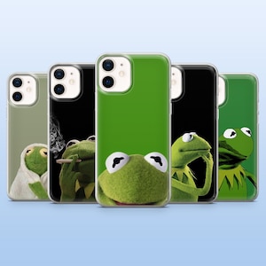May include: Five clear smartphone cases featuring various printed graphics of a green frog character. The designs include the frog wrapped in a white towel, smoking, looking forward, resting a hand on its chin, and a close-up portrait of the frog.