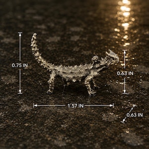 May include: A metallic bronze-toned horned lizard figurine with a textured, spiky surface. The figure measures 0.75 inches in height, 1.57 inches in length, 0.63 inches in width, and 0.63 inches in height at the head, as indicated by the labels.