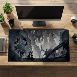 May include: A rectangular desk mat featuring a black and white illustration of characters from the video game Hollow Knight, including the Knight and various creatures set against a dark, atmospheric forest background with tall, pointed trees.