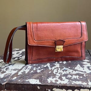 Bolso de mano vintage de los años 70, de piel color marrón castaño, con dos compartimentos.