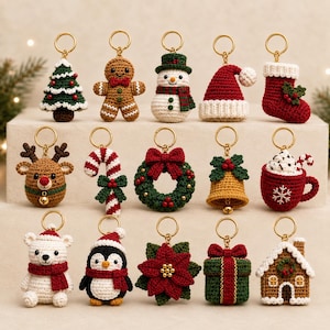 Può includere: Una collezione di quindici portachiavi all'uncinetto a tema natalizio con vari disegni tra cui un albero, un omino di pan di zenzero, un pupazzo di neve, un cappello di Babbo Natale, una calza, una renna, un bastoncino di zucchero, una ghirlanda, una campana, una tazza, un orso polare, un pinguino, una stella di Natale, un regalo e una casa.