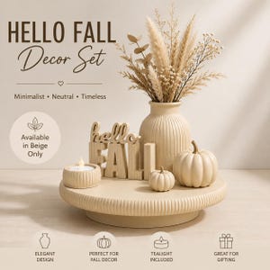 May include: A beige decor set featuring a round ribbed tray, a ribbed vase filled with dried grasses, two smooth pumpkins, a small candle holder with a tealight, and a wooden sign with the text HELLO FALL and Minimalist Neutral Timeless.
