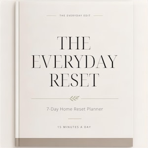 Może przedstawiać: Biały planer zatytułowany THE EVERYDAY RESET z podtytułem 7-Day Home Reset Planner oraz tekstem 15 MINUTES A DAY. Okładka zawiera u góry napis THE EVERYDAY EDIT, małą ikonę liścia oraz ciemnoszary poziomy pasek u dołu strony.