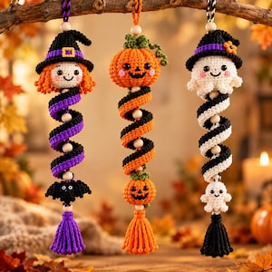 May include: Three hanging crochet ornaments featuring Halloween themes. The left ornament has a witch, purple spiral, and bat. The center has a pumpkin, orange and black spiral, and small pumpkin. The right has a ghost, black and white spiral, and small ghost.