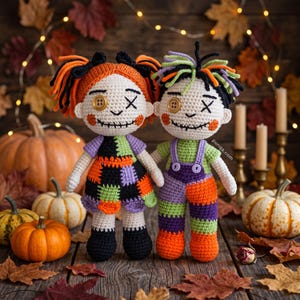 May include: Two handmade crochet dolls featuring stitched facial features, button eyes, and yarn hair. The left doll wears a patchwork dress in orange, black, and green, while the right doll wears green and purple overalls. Text reads punqa.com.