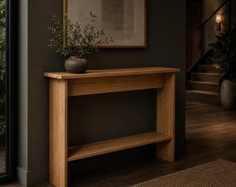May include: A rectangular light brown wooden console table featuring a flat top surface and a lower shelf. The table is constructed with vertical side panels and a horizontal support beam beneath the top surface, showcasing a natural wood grain finish.