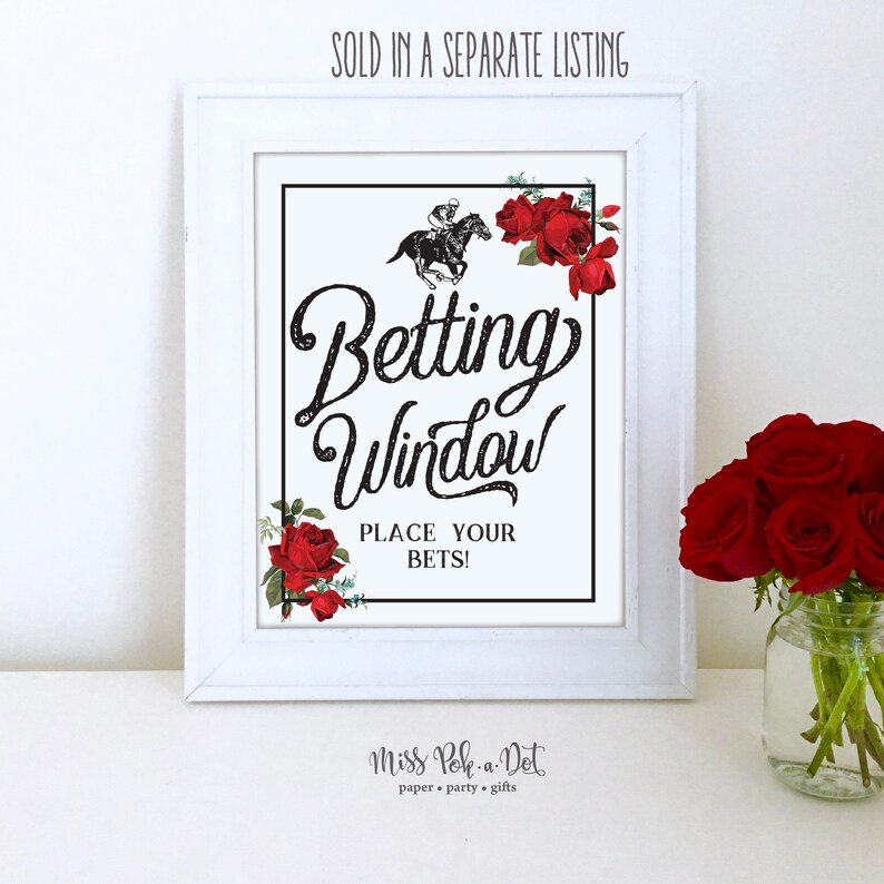 May include: A white framed sign with the words "Betting Window" in a decorative font, featuring a horse racing graphic and red roses. The text "PLACE YOUR BETS!" is below. The sign is for a betting window.