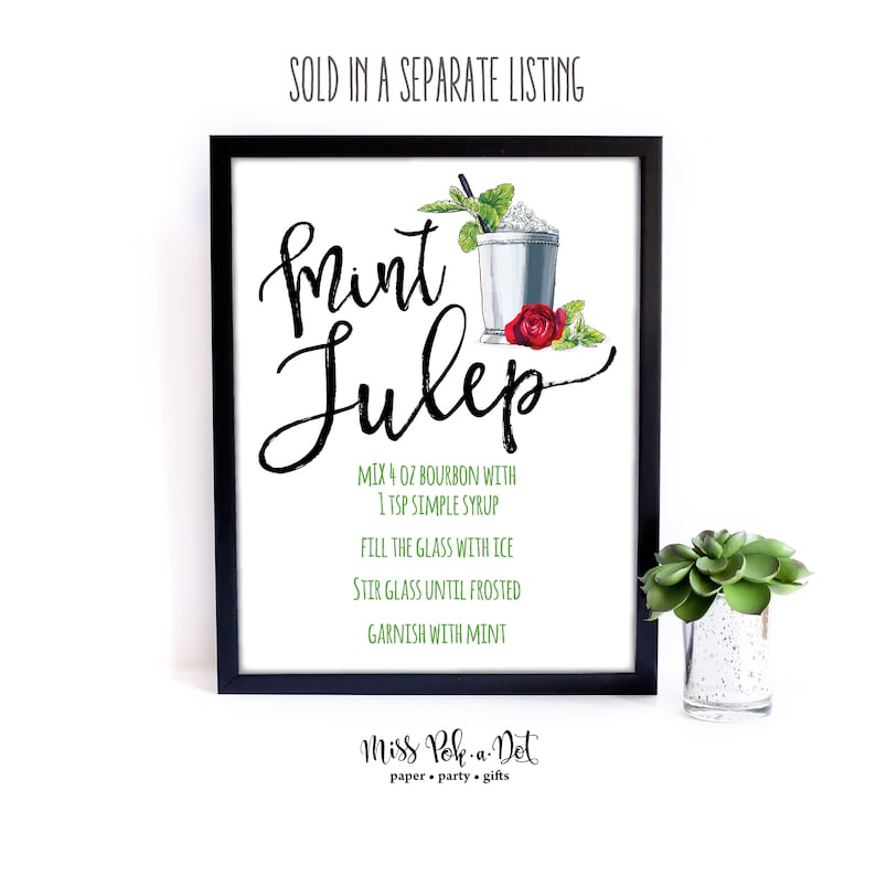 K&ouml;nnte beinhalten: Gerahmter Druck mit schwarzem Rahmen, der ein Mint Julep-Rezept in eleganter Schrift zeigt. Das Rezept enth&auml;lt Bourbon, Zuckersirup, Eis und Minze. Eine Aquarellillustration eines Cocktails, Minzzweige und eine rote Rose.