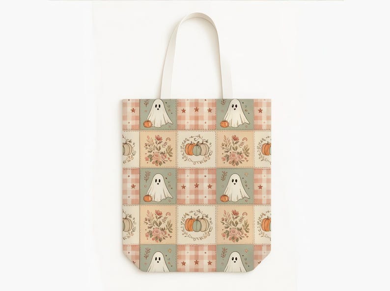 May include: A tote bag featuring a repeating patchwork pattern of ghosts, pumpkins, and floral arrangements in muted orange, green, and cream tones. The design includes checkered squares with small stars and ghost illustrations on a light background.