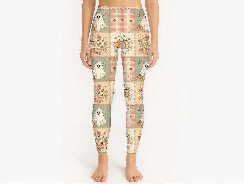 May include: Leggings featuring a patchwork-style grid pattern in muted tones of beige, sage green, and soft orange. The design includes repeating illustrations of white ghosts, orange pumpkins, and floral bouquets, interspersed with plaid squares.