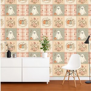 May include: Wallpaper featuring a repeating grid pattern of alternating squares. One set of squares displays white ghosts with orange pumpkins on a plaid background, while the other set shows floral arrangements with pumpkins in muted earth tones.