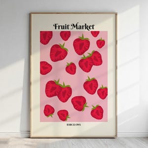 Peut inclure: Une affiche murale rectangulaire avec le texte Fruit Market en haut et BARCELONA en bas. Le motif central présente une répétition de moitiés de fraises rouges sur un fond rose clair, le tout encadré par une bordure de couleur crème.