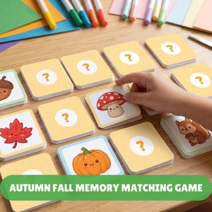May include: A memory matching game featuring square cards with autumn-themed illustrations including an acorn, a mushroom, a maple leaf, a squirrel, and a pumpkin. Several cards are face-down with a question mark pattern.