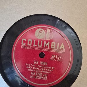 May include: A black vinyl phonograph record with a circular red center label featuring the Columbia logo at the top. The text reads Say When, Fox Trot - Vocal Chorus by Sully, Ginny, Jack & Max -Keene-Bean-Masters- Kay Kyser and his Orchestra.