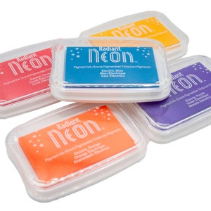 Pu&ograve; includere: Cinque tamponi d'inchiostro in custodie di plastica trasparente con le parole "Radiant Neon" e i colori dell'inchiostro: corallo, blu elettrico, arancione, viola elettrico e giallo.