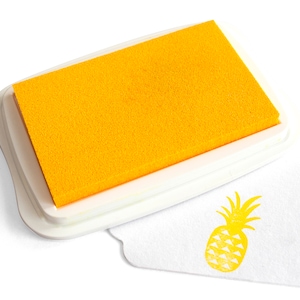 Pu&ograve; includere: Un tampone d'inchiostro giallo con una custodia in plastica bianca e un timbro di ananas giallo su una superficie bianca.