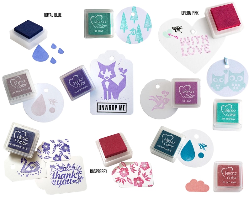 Pode incluir: Conjunto de almofadas de tinta VersaColor em v&aacute;rias cores, incluindo azul royal, rosa &oacute;pera, framboesa e lil&aacute;s. As almofadas de tinta est&atilde;o dispostas sobre um fundo branco com v&aacute;rios elementos de papel decorativos, incluindo etiquetas, cora&ccedil;&otilde;es e c&iacute;rculos. As almofadas de tinta s&atilde;o ideais para carimbar e artesanato.