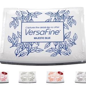 Puede incluir: Tinta Versafine en Majestic Blue. La almohadilla de tinta es blanca con un dise&ntilde;o floral azul y el texto "Captures fine details like no other Versafine Majestic Blue".