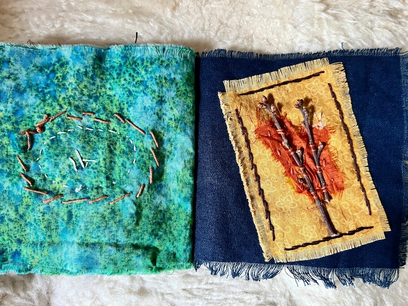 Puede incluir: Un libro hecho a mano con dos p&aacute;ginas. La p&aacute;gina izquierda es de tela azul y verde con un c&iacute;rculo marr&oacute;n cosido alrededor del borde. La p&aacute;gina derecha es de tela azul oscuro con un cuadrado de tela amarillo en el centro. El cuadrado de tela amarillo tiene un dise&ntilde;o de ramitas marrones y un peque&ntilde;o trozo de tela naranja en el centro.