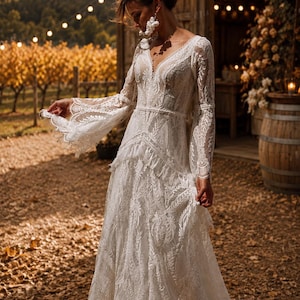 May include: A floor-length white lace dress featuring long, flared sleeves, a deep V-neckline, and intricate floral embroidery throughout. The garment includes a fitted bodice with a defined waistline and a flowing skirt with layered lace detailing.