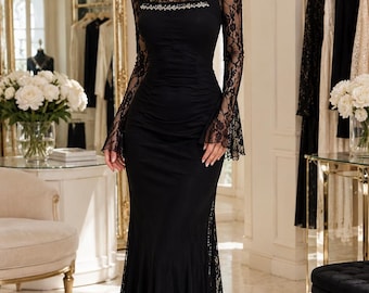 May include: A floor-length black dress featuring long lace sleeves with flared cuffs, a square neckline with a decorative beaded trim, and a ruched bodice. The skirt includes lace side panels that extend to the hem, creating a fitted silhouette.