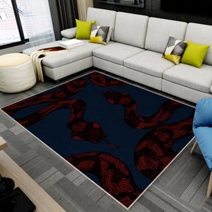 May include: A rectangular area rug featuring a dark navy blue background with a repeating pattern of deep red snakes. The snakes are depicted with a detailed, textured scale design and visible tongues, covering the entire surface of the rug.