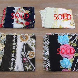 May include: Four different floral scarves with lace trim. The scarves are black, white, and blue with floral patterns. The scarves are all sold.