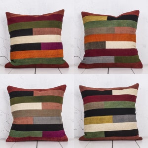 Könnte beinhalten: Vier dekorative Kissen mit Patchwork-Muster in verschiedenen Rot-, Orange-, Grün-, Braun-, Schwarz-, Weiß- und Lilatönen. Die Kissen sind in zwei Reihen zu je zwei angeordnet.