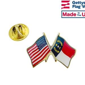 Puede incluir: Pin de solapa dorado con una bandera estadounidense y una bandera del estado de Carolina del Norte cruzadas. El pin tiene un cierre de seguridad en la parte posterior. Hecho en los Estados Unidos. Gettysburg Flag Works.
