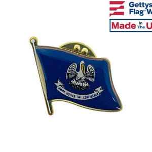 May include: A gold-colored lapel pin featuring the state flag of Louisiana. The flag is blue with a white pelican and the words "Union, Justice, and Confidence" on a white ribbon.