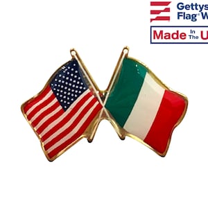 May include: A gold-toned pin featuring the flags of the United States and Italy crossed. The American flag has red and white stripes with a blue field of white stars. The Italian flag has green, white, and red vertical stripes. The pin is labeled "Made in the USA."