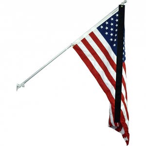 May include: A white flagpole with a black flag strap attached to a white wall mount. A US flag is attached to the flagpole and is waving in the wind.