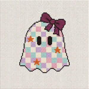 May include: A cross-stitch pattern of a ghost featuring a checkered pastel pink, blue, and purple grid design. The ghost has two black oval eyes, three orange star accents, and a dark purple bow attached to the top of its head on white canvas.